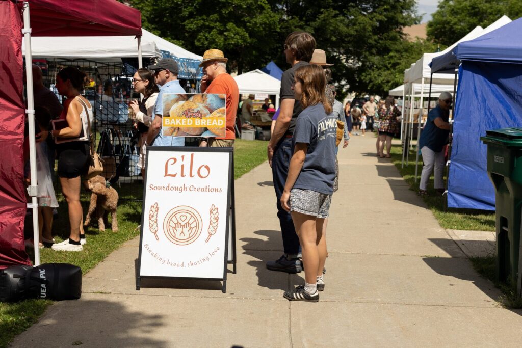 Vendors and visitors at an outdoor craft market in downtown Lee