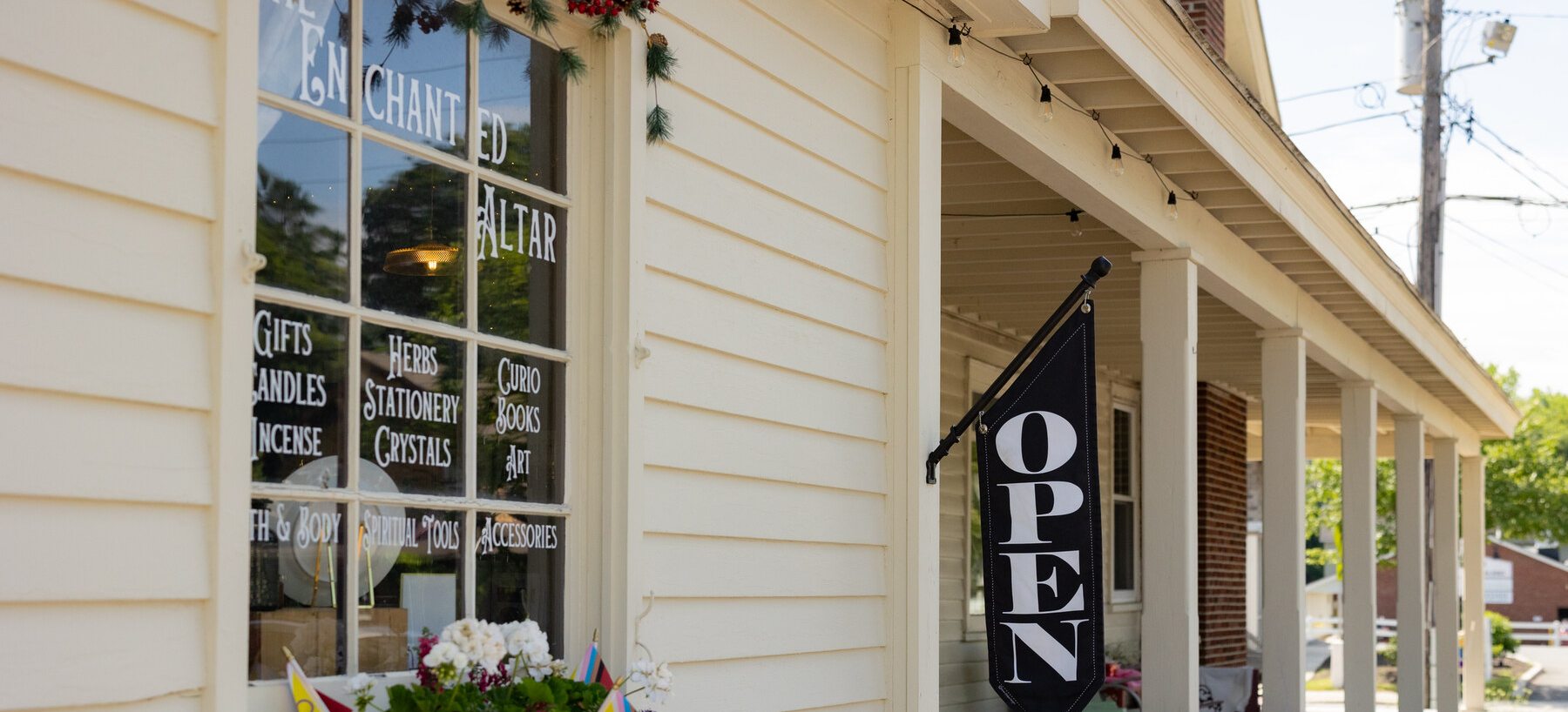An open storefront with an OPEN sign on a Lee shopping street