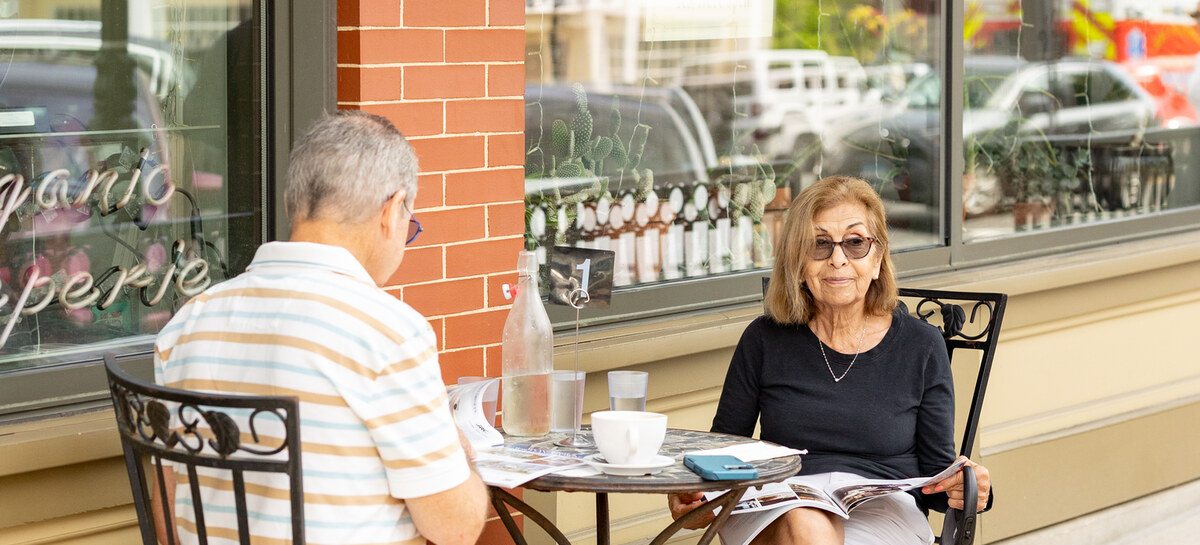 Guests at a downtown Lee sidewalk cafe table with a small dog