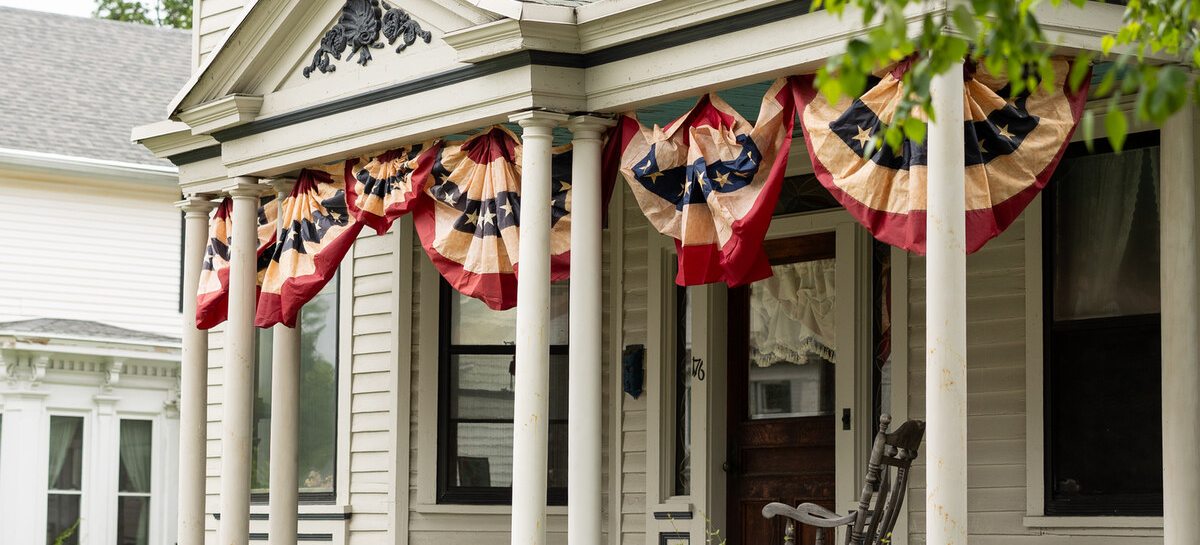 A historic Victorian home with flag bunting in Lee, evoking a bed and breakfast